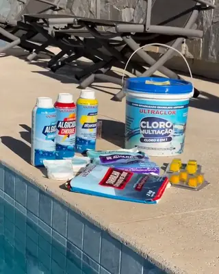 Produtos Ultraclor, cloro multiação e algicidas, organizados na borda da piscina