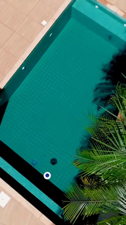 Drone sobre piscina estreita azul-escura com espreguiçadeiras