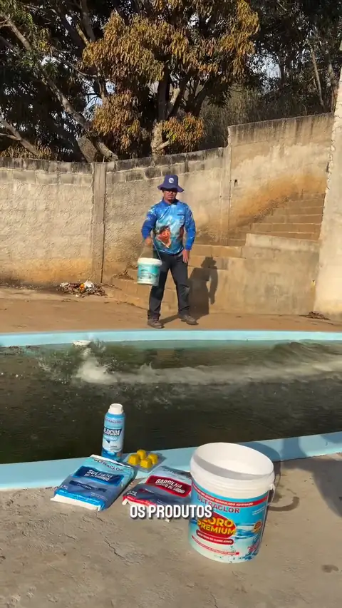 Equipe de uniforme aplicando produtos numa piscina de água verde
